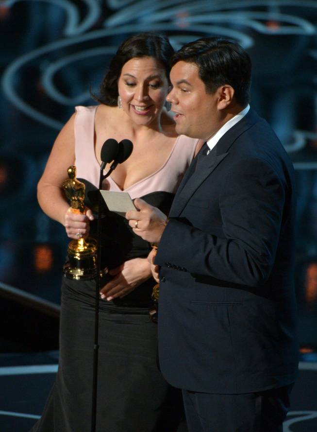 Kristen Anderson-Lopez, left, and Robert Lopez accept the award for an original song in a feature film for "Let It Go" from "Frozen" during the Oscars at the Dolby Theatre on Sunday, March 2, 2014, in Los Angeles.  (Photo by John Shearer/Invision/AP)